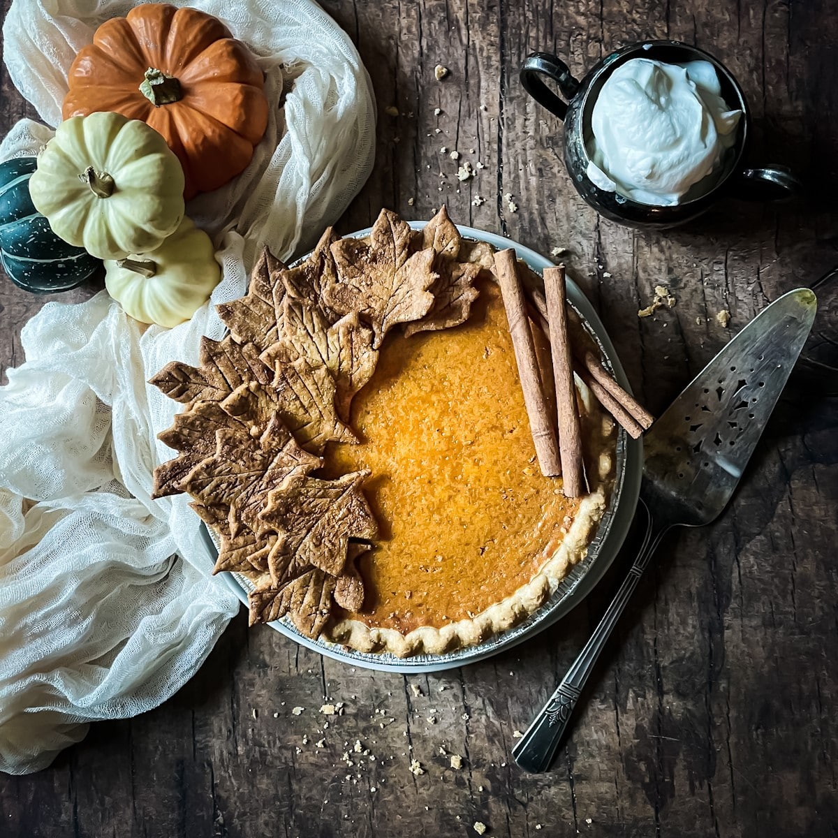 Honey pumpkin pie with pastry leaves and cinnamon sticks