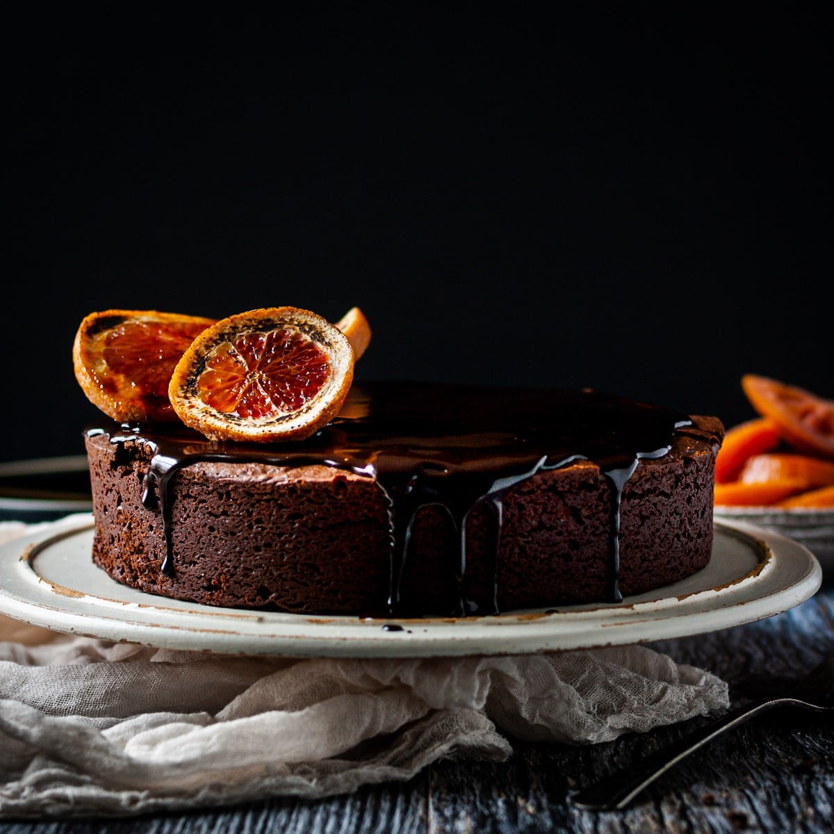 Front view of a Grand Marnier boozy blood orange chocolate cake with chocolate ganache drizzle.