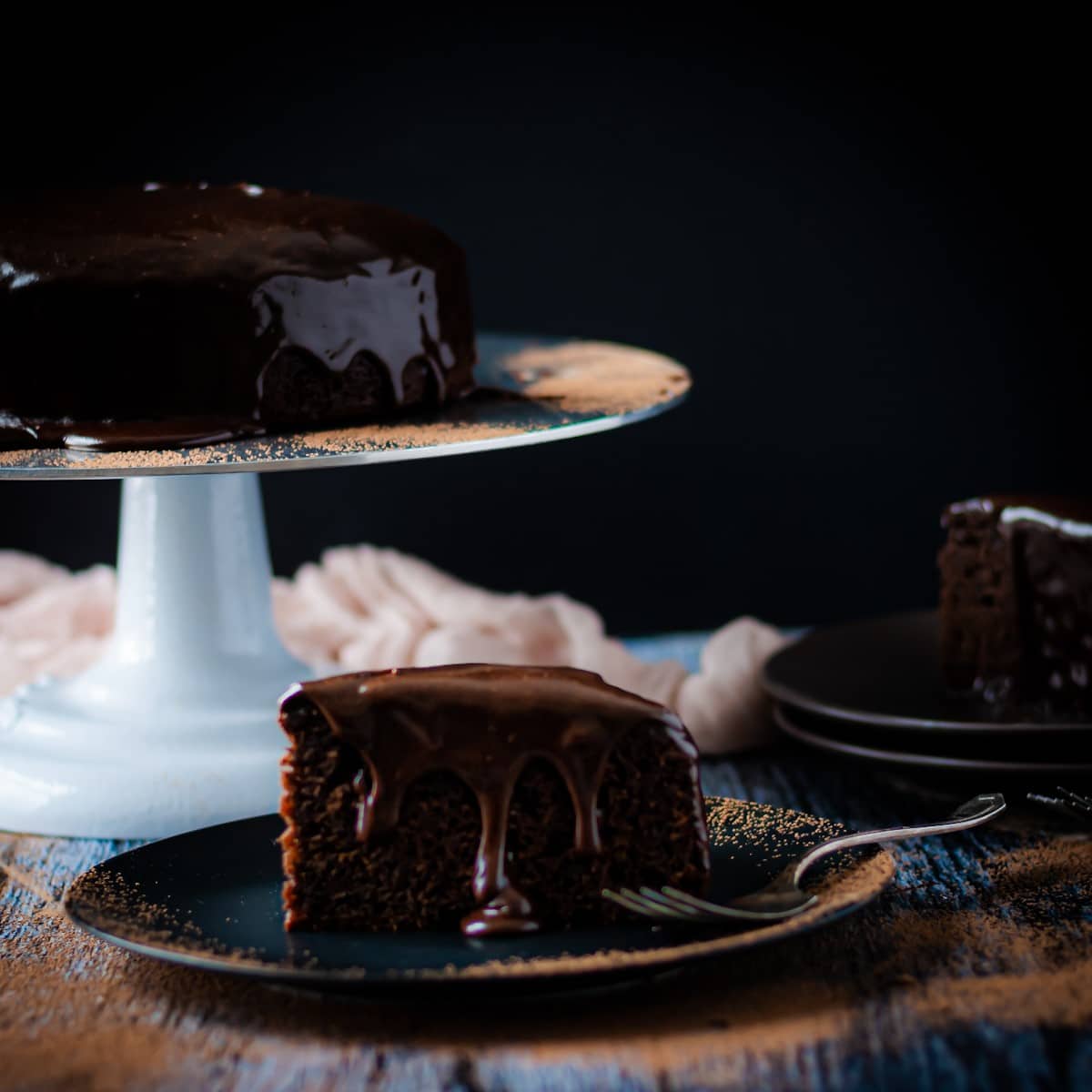 slice of chocolate brownie cake on a plate with chocolate ganache drizzle