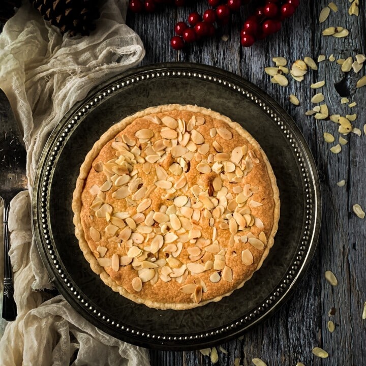 Overhead shot of whole italian almond tart on a plate with a napkin.