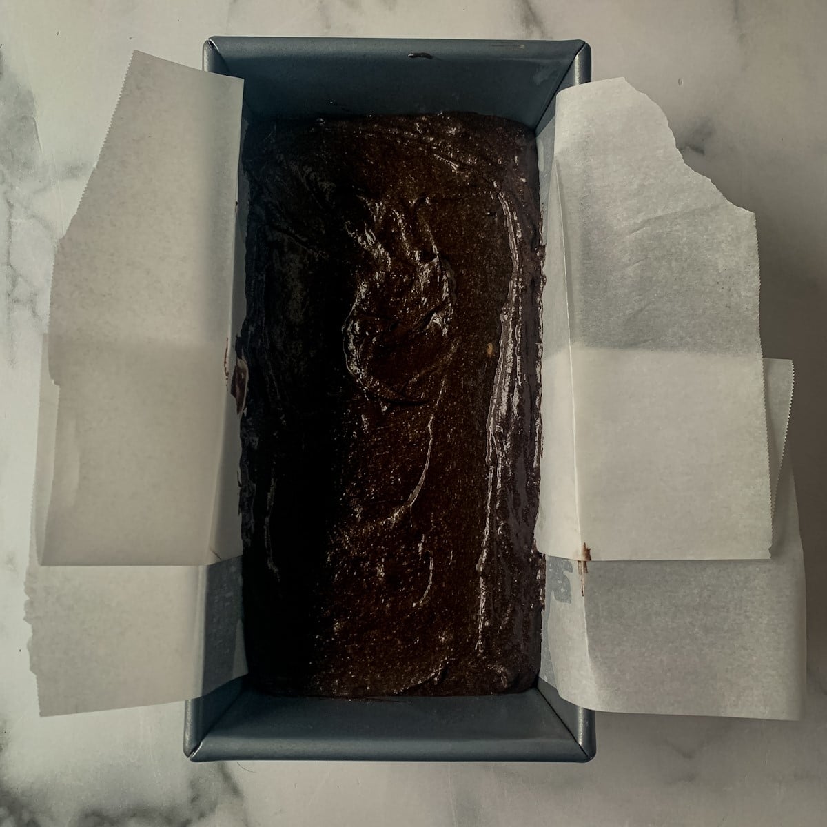Chocolate loaf cake batter in prepared loaf pan.
